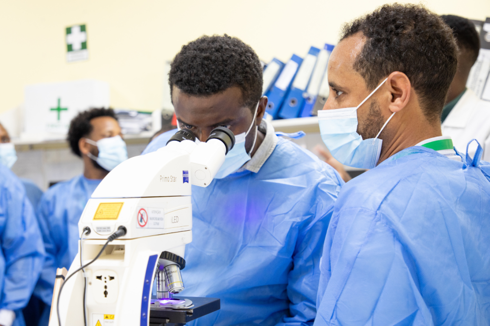 CryptoT&T Project researchers in a laboratory with a microscope